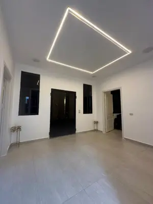 a large white room with a large light fixture on the ceiling at Hassan