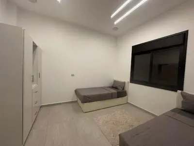 a bedroom with a bed and a flat screen tv at Hassan