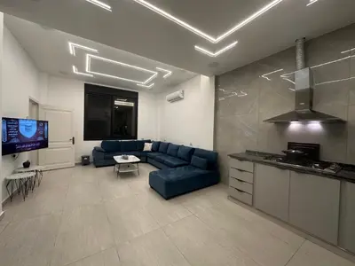 a living room with a blue couch and a tv at Hassan