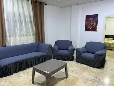 a living room with two blue couches and a table at دار زمان Zaman Suites Old Town in Al Mafraq