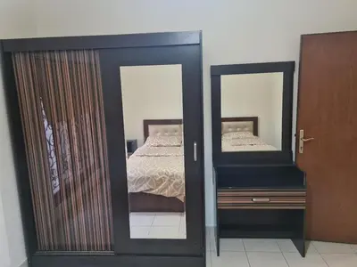 a bedroom with a bed and two mirrors at Apartment in Abdoun Al Janobi in Amman