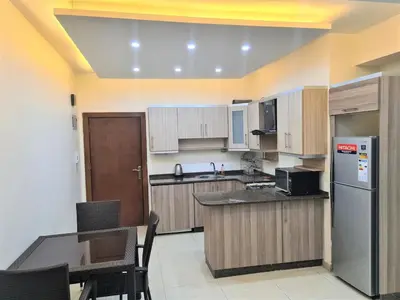 a large kitchen with a table and a refrigerator at Apartment in Abdoun Al Janobi in Amman