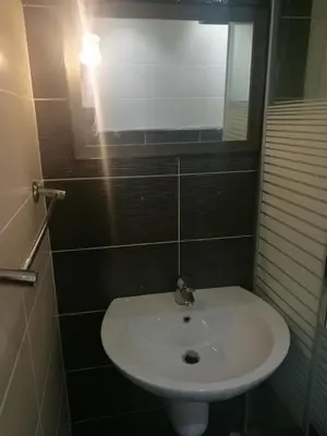 a bathroom with a white sink and a mirror at Apartment in Abdoun Al Janobi in Amman