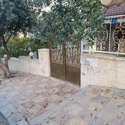 a gate to a house with a tree next to it at Bourbaki house