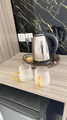 a tea kettle and two cups on a counter at WADI RUM OLIVIA lUXURY CAMP & TOUR in Wadi Rum