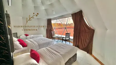 a bedroom with two beds and a window at WADI RUM OLIVIA lUXURY CAMP & TOUR in Wadi Rum