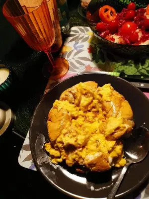 a plate of scrambled eggs on a table with a drink at المناخير هوستل in Amman