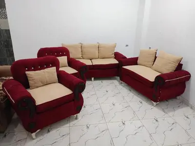 three red chairs and a couch in a room at المناخير هوستل in Amman