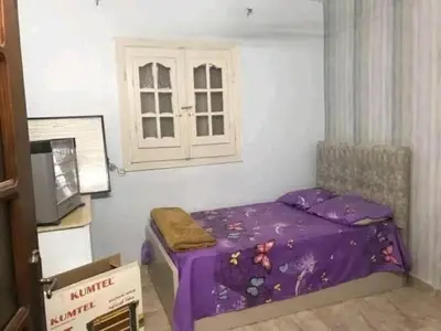 a bedroom with a purple bed and a window at المناخير هوستل in Amman
