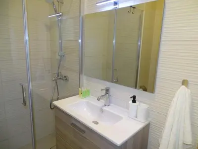 a bathroom with a sink and a shower with a mirror at B12 beach apartment Ayla in Al Jafr