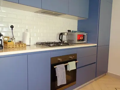 a blue kitchen with a stove and a microwave at B12 beach apartment Ayla in Al Jafr