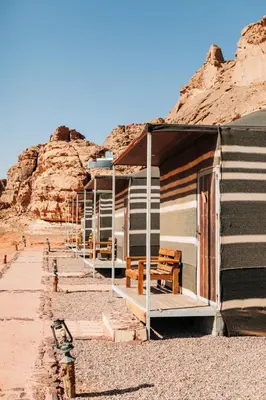 a row of houses with benches in the desert at Luxury diamond camp in Wadi Rum