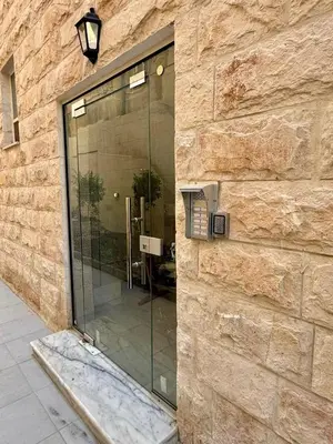 a glass door on the side of a stone building at Beit Ahlan Suites 7 in Amman