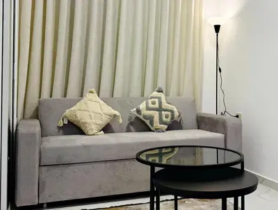 a living room with a couch with pillows and a table at Beit Ahlan Suites 7 in Amman