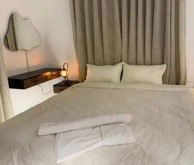 a white bed with white sheets and pillows at Beit Ahlan Suites 8 in Amman