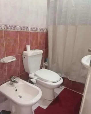 a bathroom with a white toilet and a sink at 10 seasoun House in Dawqarah