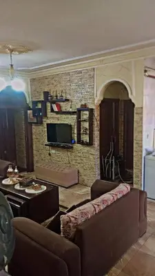 a living room with two couches and a tv at 10 seasoun House in Dawqarah