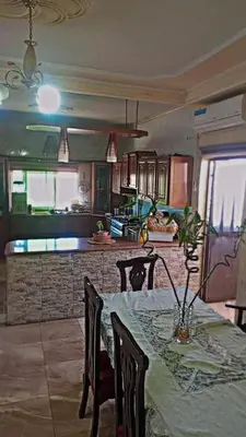 a kitchen with a table and chairs with a table and a counter at 10 seasoun House in Dawqarah