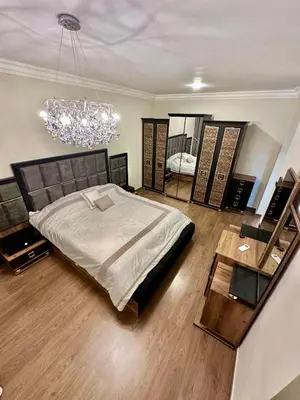 a bedroom with a large bed and a chandelier at Modern Residence for families only in Amman