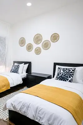 two beds in a bedroom with plates on the wall at Apartment in Amman 7th Circle near Cozmo market in Amman