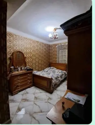 a bedroom with a bed and a dresser and a mirror at mraco apartment in Amman