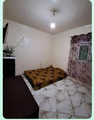 a small bedroom with a bed and a window at mraco apartment in Amman