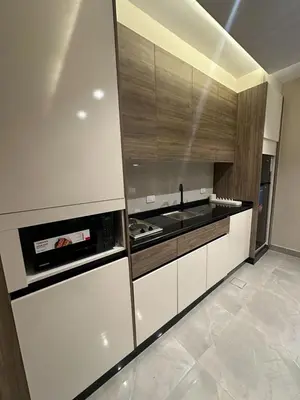 a kitchen with white cabinets and a stove top oven at Charming Amman Apartment with Modern furnis in Amman