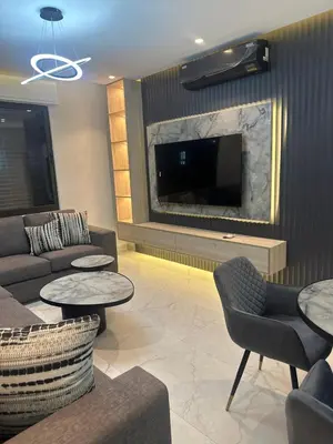 a living room with a couch and tables and a tv at Apartment in dergbar in Amman