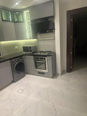 a kitchen with a stove and a washing machine at Apartment in dergbar in Amman