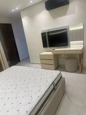 a bedroom with a bed and a desk with a flat screen tv at Apartment in dergbar in Amman