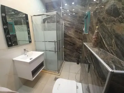 a bathroom with a shower and a toilet and a sink at Amman Central Elegant Apartment in Amman