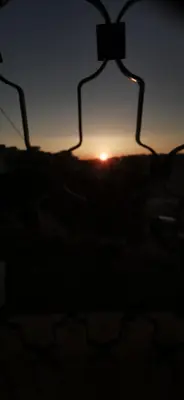 a sunset seen through a window of a building at A large, fully furnished Apartment in Amman