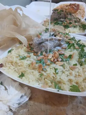 a plate of food with rice and beans and meat at العنبق هاوس