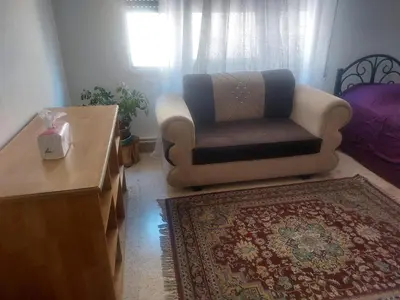 a living room with a chair and a table at Room in central Amman in Amman