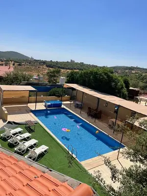 a large swimming pool with lounge chairs at Chalet Adam- Ajloun شاليه ادم in Ajloun
