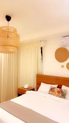 a bedroom with a white bed and a chandelier at Villa Saya in Jerash