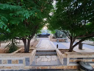 a walkway with trees and a car in the distance at Villa Saya in Jerash