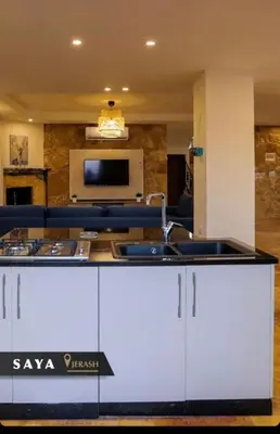 a kitchen with a counter top in a living room at Villa Saya in Jerash