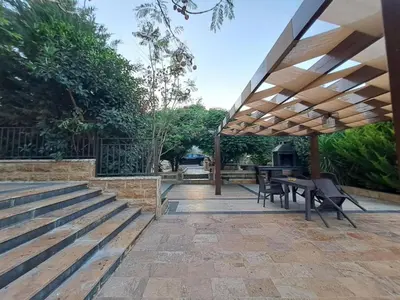 a patio with a table and chairs under a pavilion at Villa Saya in Jerash