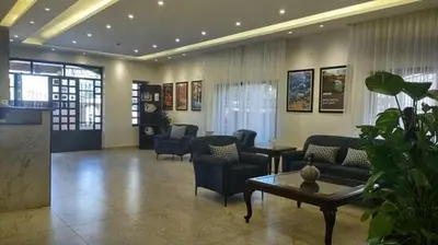 a lobby with couches and a table and chairs at Black Iris Hotel in Madaba