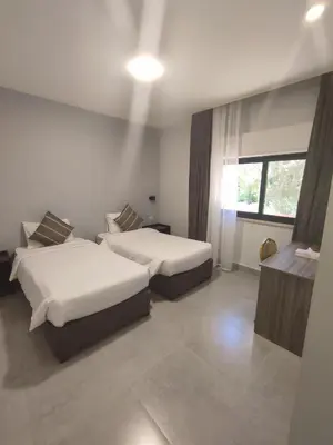 a hotel room with two beds and a window at Black Iris Hotel in Madaba