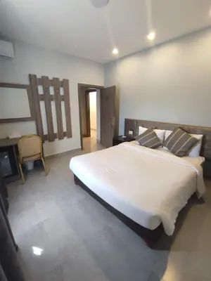 a bedroom with a large white bed with pillows at Black Iris Hotel in Madaba