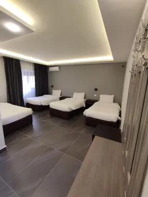 a room with four beds in a room at Black Iris Hotel in Madaba