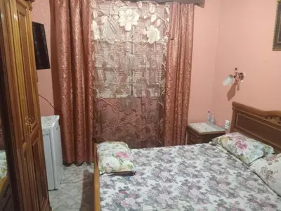 a small bedroom with a bed and a curtain at Zomik house in Al Qiḩāţī