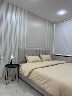 a bedroom with a large bed with a lamp on a table at sky view rooftop in Amman
