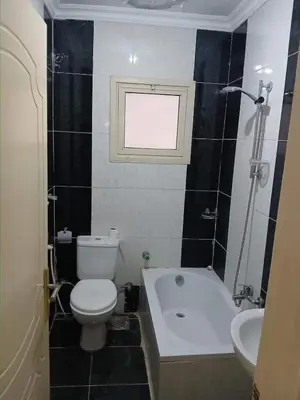 a bathroom with a toilet and a tub and a sink at Nargges House in Al Salt