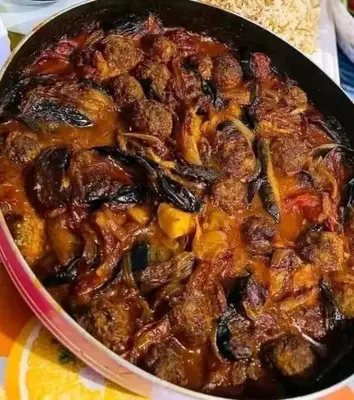 a pan of food with meat and vegetables in at Nargges House in Al Salt