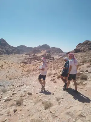 a group of people walking through the desert at saleem with jeep tour in Wadi Rum