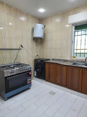 a kitchen with a stove and a sink and a microwave at Monani in Amman