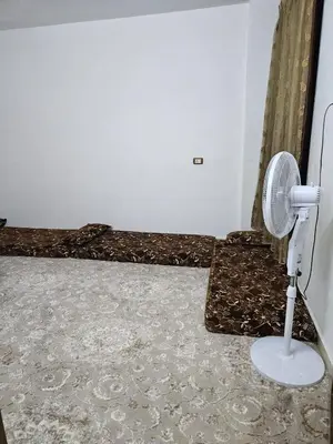 a room with a bed and a fan on the floor at غصن الزيتون in Ajloun